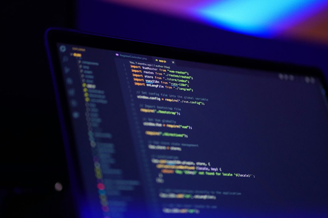 Laptop screen showing clean source code in a dark editor with blue lighting