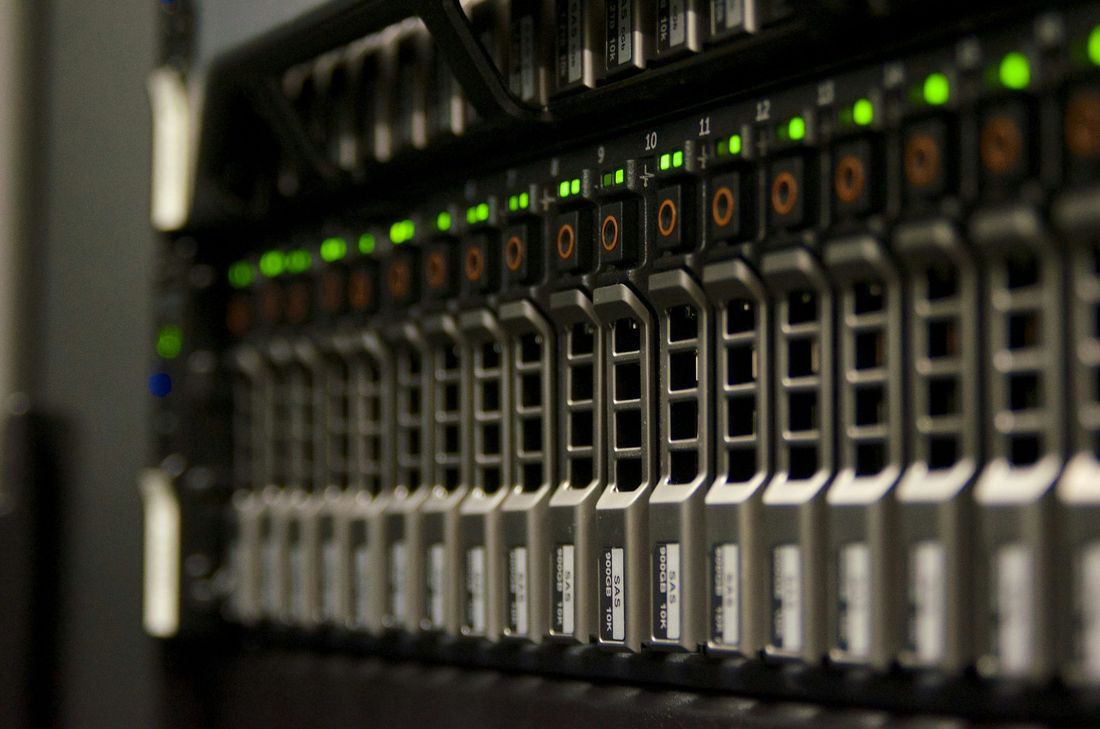 Close-up of a server with rows of drive bays and green status lights, representing on-premises hardware for local AI